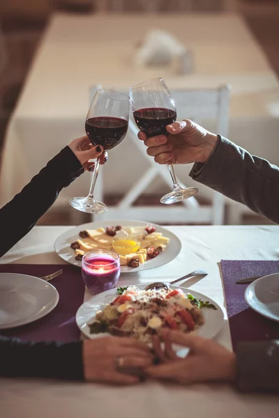 Belo jovem casal com copos de vinho tinto em restaurante de luxo — Fotografia de Stock