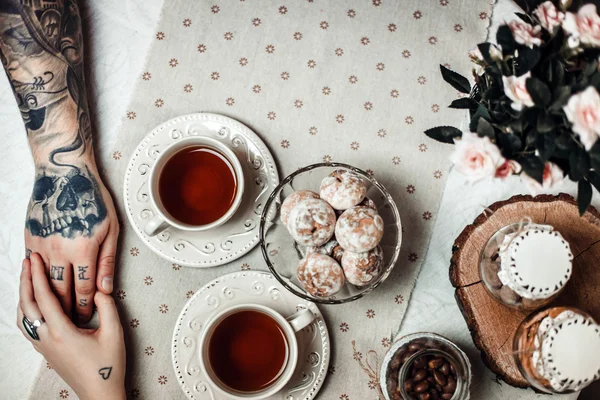 Een jongen en een meisje met twee kopjes thee — Stockfoto