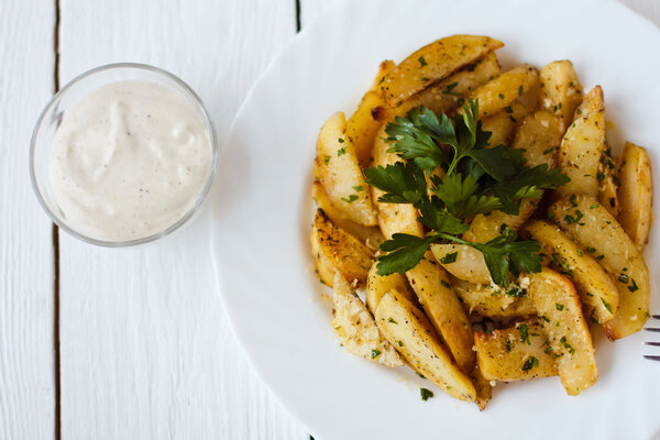 beautiful roasted potatoes with herbs and spices on a white plate
