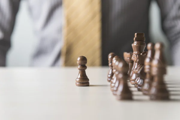 Business man moving chess figure with team behind - strategy or leadership concept