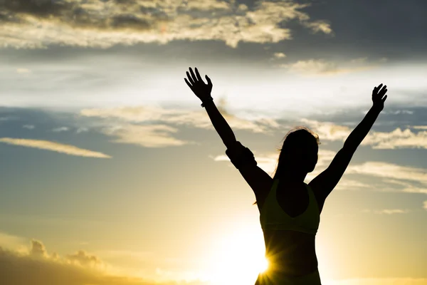 woman open arms under the sunrise at seaside