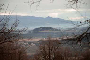 Dağın tepesindeki bir kaleyi gösteren güzel bir manzara. Katalonya 'nın Tona kasabasındaki bazı ağaç ve dalların arasında.