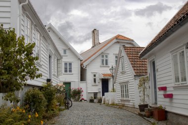 Güzel Bergen Eski Kasabası 'nda bulutlu gökyüzünün altında beyaz evler ve bir bisiklet