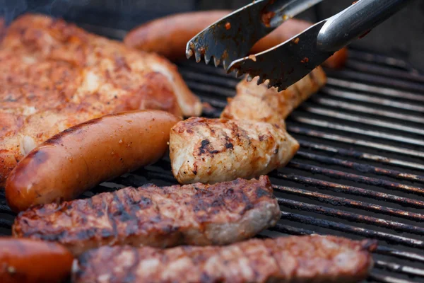 Assorted meat from chicken and pork and sausages on barbecue grill — Stock Photo, Image