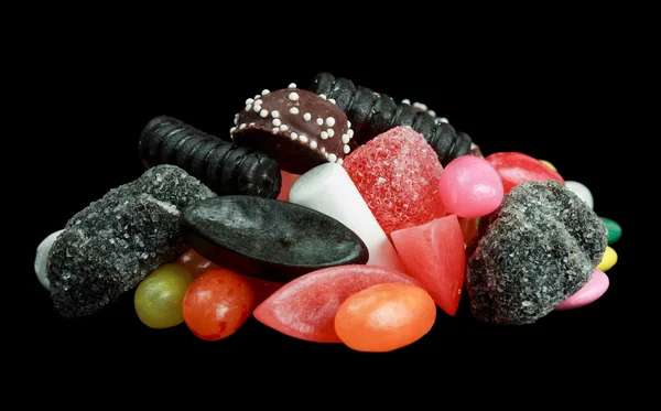 Haufen Bonbons isoliert auf schwarzem Hintergrund — Stockfoto