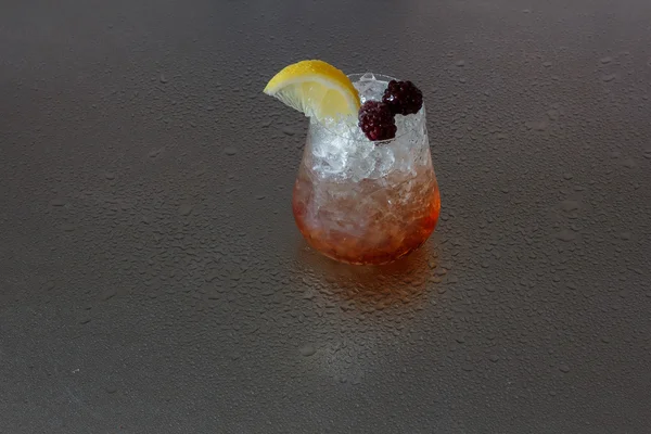 Bramble cocktail on wet metal surface — Stock Photo, Image