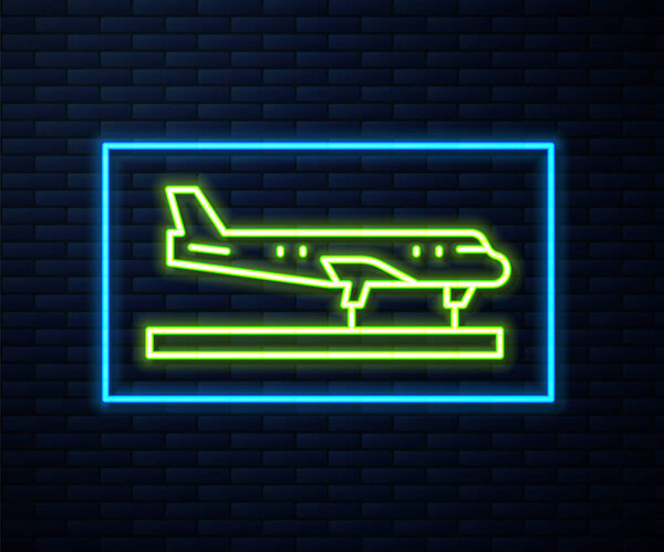 Glowing neon line Plane icon isolated on brick wall background. Flying airplane icon. Airliner sign.  Vector.