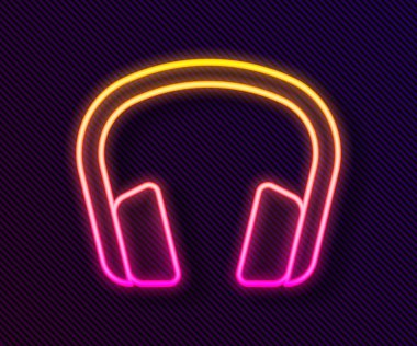 Parlayan neon hattı kulaklık simgesi siyah arkaplanda izole edildi. Kulaklıklar. Müzik, hizmet, iletişim ve operatör konsepti. Vektör