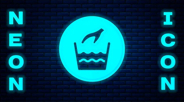 Glowing neon Hand wash laundry icon isolated on brick wall background. Vector — Stock Vector