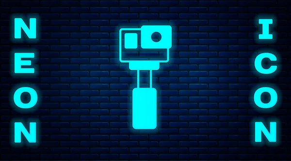 Brilhante neon Ícone de câmera extrema Ação isolado no fundo da parede de tijolo. Equipamento de câmera de vídeo para filmar esportes radicais. Vetor —  Vetores de Stock
