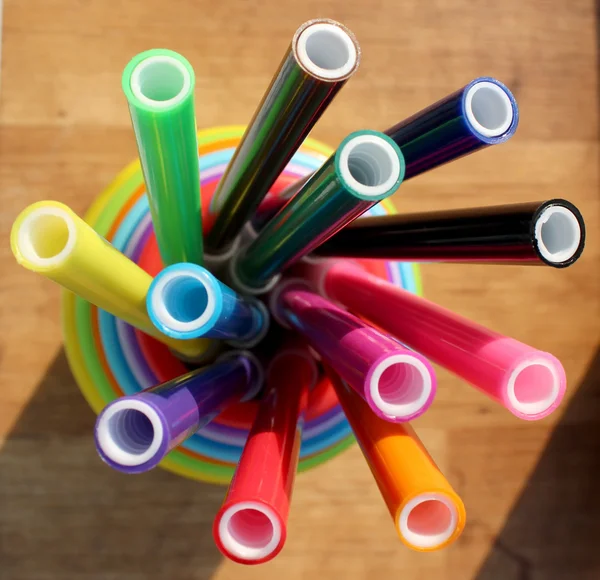 multicolored felt pens in plastic cups