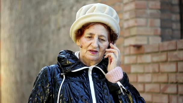 年配の女性が彼女の携帯電話で電話を屋外に作る — ストック動画