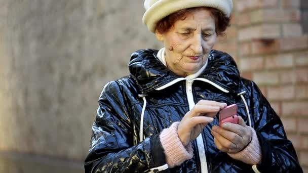 Primer plano de la mujer mayor utilizando el teléfono móvil al aire libre — Vídeo de stock