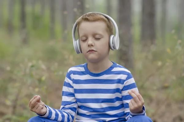 Kleiner Junge meditiert im Sommer im Wald — Stockfoto