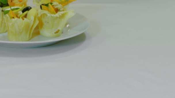 Camarero pone un plato de canapé con tomates cereza y mozzarella en una mesa de vacaciones — Vídeos de Stock