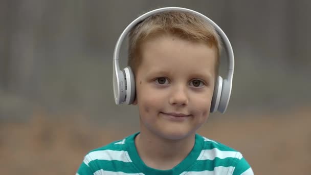 Šťastný chlapeček se sluchátky, venkovní — Stock video