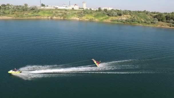 Jet Ski tirando balsa inflable con un hombre en el lago — Vídeos de Stock