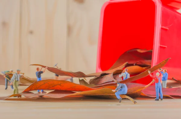 ミニフィギュア人形労働者の概念イメージ赤いごみ箱に乾燥葉を収集します 環境を安全に保つためのグループとしての意味 — ストック写真