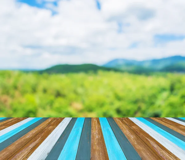 나무로 만든 탁자와 뒤에 보이는 푸른 산의 흐릿 한 이미지. — 스톡 사진