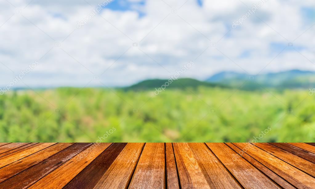 wood table and blur image of green mountain in background.