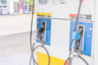 akıllı telefon ve benzin istasyonu arka planda tutan el.