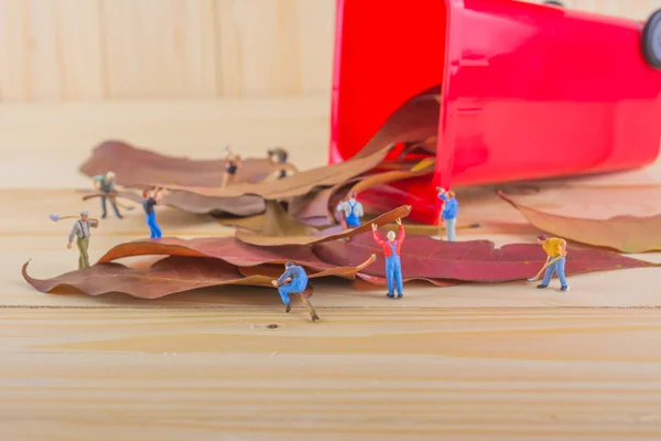 ミニフィギュア人形労働者の概念イメージ赤いごみ箱に乾燥葉を収集します 環境を安全に保つためのグループとしての意味 — ストック写真
