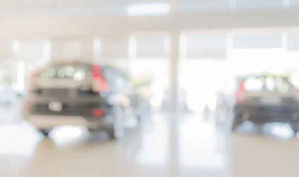 blur image of Commercially cars stand in show room of car shop for background usage .