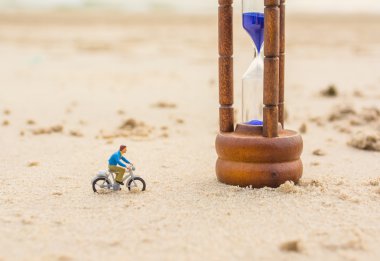 mini figür bebek motorcu ve sahilde kum saati görüntüsü  