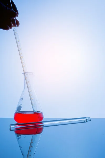 Lab glassware on glass table in warm tone. — Stock Photo, Image