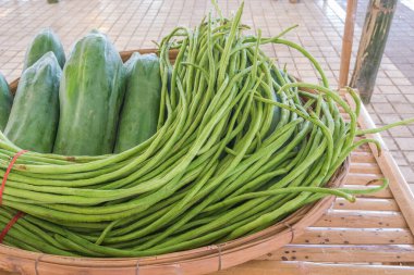 Yerel Tayland pazar saatinde bambu masasında satılık sebze resmi.