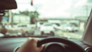 Arka plan kullanımı için gündüz vakti araba kullanan insanların klasik ton bulanık görüntüsü. (içeriden fotoğraf çek)