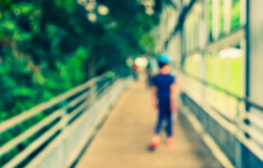 Arka plan kullanımı için uzun koridorda yeşil bahçeye yürüyen Abstrat bulanık insanları görüntüsü. (Klasik ton))