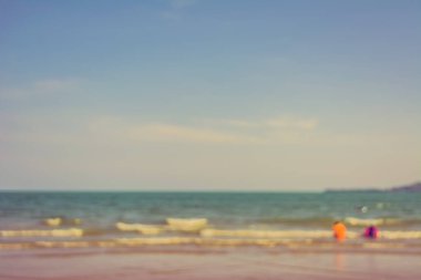 Arka plan kullanımı için sahilde yürüyen bulanık insanların soyut görüntüsü. (Klasik ton))