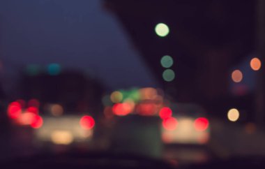 Arka plan için gece vakti trafik sıkışıklığından gelen bokeh ışıkları olan içerideki arabaların klasik ton bulanık görüntüsü.