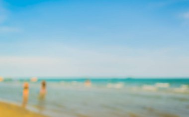 Arka plan kullanımı için sahilde yürüyen bulanık insanların soyut görüntüsü .