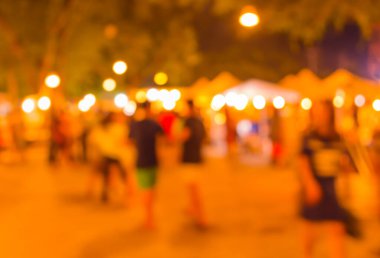 Şenlik ışıklarıyla dekore edilmiş arka plandaki bulanık gece pazarının görüntüsü. (Klasik ton))