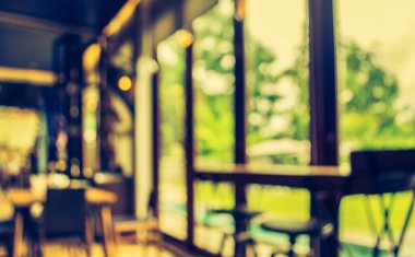 Arka plan kullanımı için Bokeh ile birlikte kahve dükkanında pencere kenarındaki bar taburesinin bulanık görüntüsü. (Klasik ton))