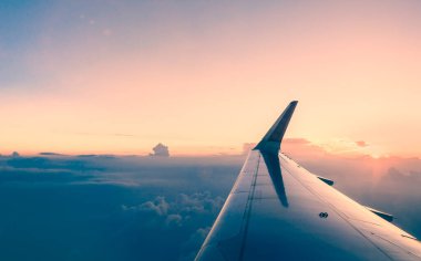 Akşam vakti gökyüzünü görmek için uçak penceresinden bak.