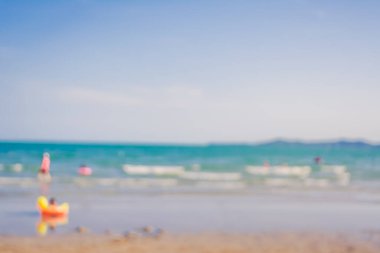 Arka plan kullanımı için sahilde yürüyen bulanık insanların soyut görüntüsü. (Klasik ton))