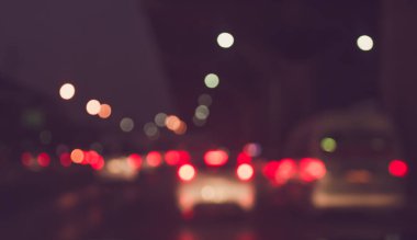 Arka plan için gece vakti trafik sıkışıklığından gelen bokeh ışıkları olan içerideki arabaların klasik ton bulanık görüntüsü.