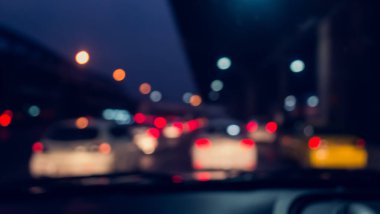 Arka plan için gece vakti trafik sıkışıklığından gelen bokeh ışıkları olan içerideki arabaların klasik ton bulanık görüntüsü.