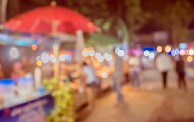 Şenlik ışıklarıyla dekore edilmiş arka plandaki bulanık gece pazarının görüntüsü. (Klasik ton))