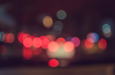 Arka plan için gece vakti trafik sıkışıklığından gelen bokeh ışıkları olan içerideki arabaların klasik ton bulanık görüntüsü.