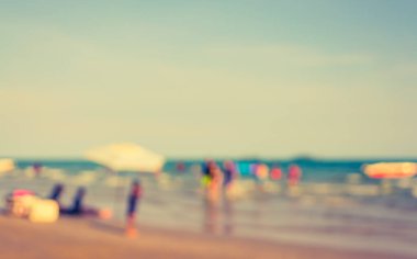 Arka plan kullanımı için sahilde yürüyen bulanık insanların soyut görüntüsü. (Klasik ton))