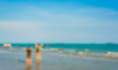 Arka plan kullanımı için sahilde yürüyen bulanık insanların soyut görüntüsü .