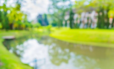 Arkaplan kullanımı için Bokeh ile yeşil parktaki bulanık gölet görüntüsü .