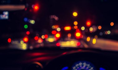 Arka plan kullanımı için gece vakti araba kullanan insanların klasik ton bulanık görüntüsü. (içeriden fotoğraf çek)