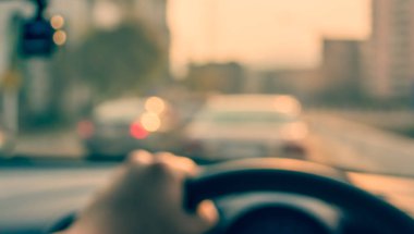 Arka plan kullanımı için gündüz vakti araba kullanan insanların klasik ton bulanık görüntüsü. (içeriden fotoğraf çek)