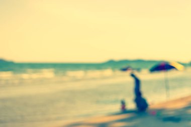 Arka plan kullanımı için sahilde yürüyen bulanık insanların soyut görüntüsü. (Klasik ton))