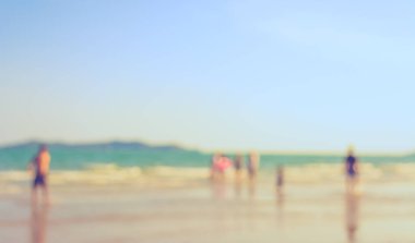 Arka plan kullanımı için sahilde yürüyen bulanık insanların soyut görüntüsü. (Klasik ton))